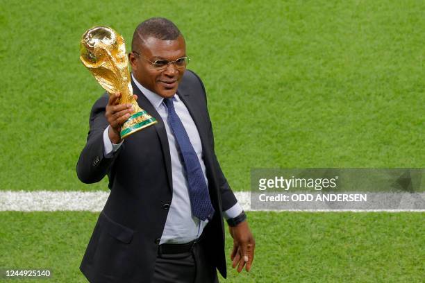 French former football player Marcel Desailly holds the FIFA World Cup trophy ahead of the Qatar 2022 World Cup Group A football match between Qatar...