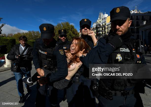 Graphic content / Spanish policemen retain a member of the feminist activist group Femen as they protest against a far right demonstration marking...