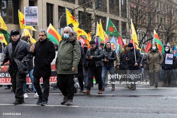 November 2022, Hessen, Frankfurt/Main: Demonstrators cross the street during the demonstration against the bombing of Kurdish areas in Syria. In...