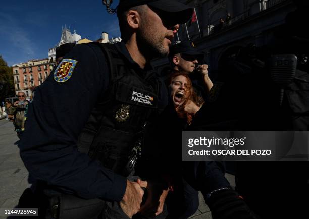 Spanish policemen retain a member of the feminist activist group Femen as they protest against a far right demonstration marking the anniversary of...