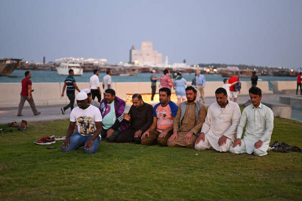Migrant workers pray on the Corniche in Doha, Qatar on 20 November 2022 in the build up to the FIFA World Cup Qatar 2022.