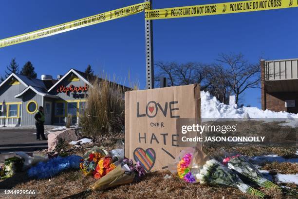 Bouquets of flowers and a sign reading "Love Over Hate" are left near Club Q, an LGBTQ nightclub in Colorado Springs, Colorado, on November 20, 2022....