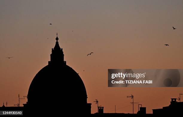 This picture taken on November 20, 2022 at sunset shows a view from Rome of St. Peter basilica in The Vatican.