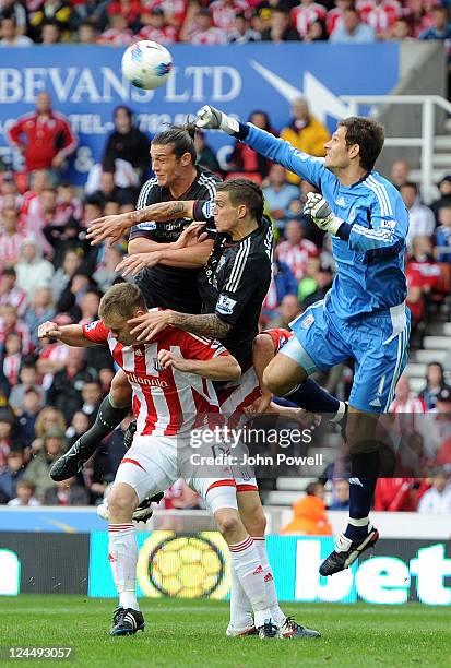 Andy Carroll and Daniel Agger of Liverpool both go up with Asmir Begovic and Ryan Shawscross of Stoke City during the Barclays Premier League match...