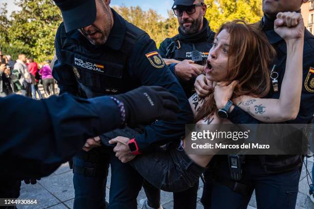 An activist of feminist group FEMEN is carried and removed by police officers while shouting slogans against fascism at the beginning of a gathering...