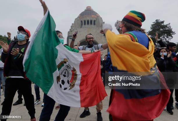 Clown carrying a flag of the Ecuadorian soccer team and a woman with the Mexican flag, celebrate a goal by the Ecuadorian soccer team during the FIFA...