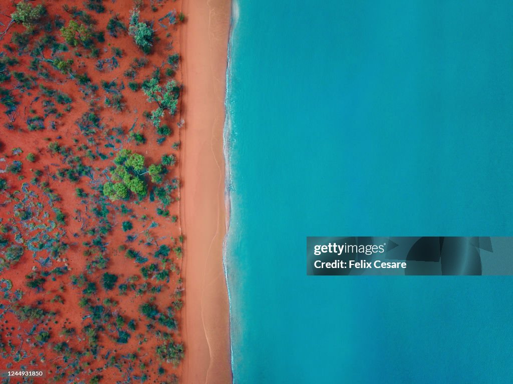 Aerial top view of a bright orange sandy beach