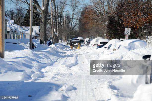 Buffalo, NY Pedestrians attempt to dig out cars after an intense lake-effect snowstorm that impacted the area on November 20, 2022 in Buffalo, New...