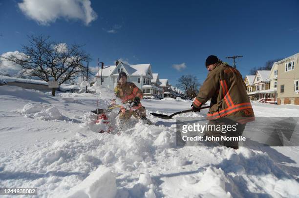 Buffalo, NY Fire fighters Larry McPhail and Nick Eoanno clear fire hydrants after an intense lake-effect snowstorm that impacted the area on November...