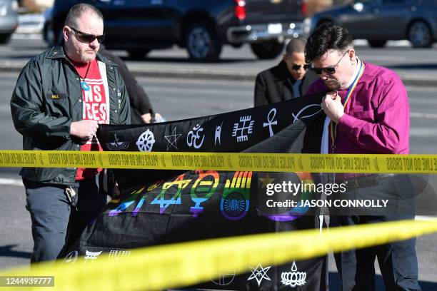 Michael I. Travis and Dr. Michael R. Travis place a flag at a memeorial for the victims of a mass shooting at Club Q, an LGBTQ nightclub, in Colorado...