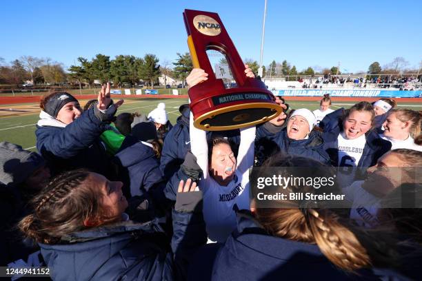 Middlebury College Panthers Charlotte Marks holds the championship trophy while celebrating with teammates after defeating Johns Hopkins Blue Jays in...