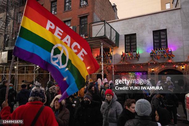 Person holds a rainbow flag during a vigil on Trans Day of Remembrance at The Stonewall Inn in New York City on November 20, 2022.