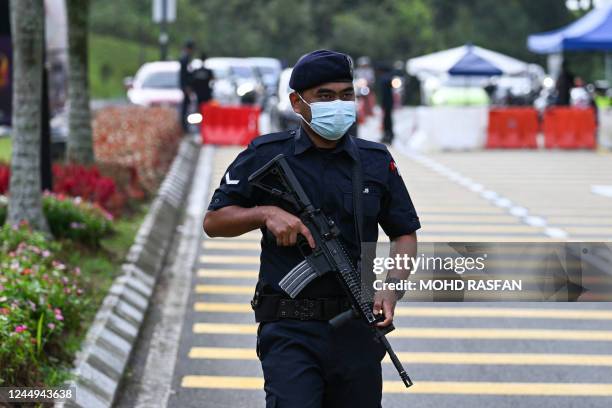 Royal Malaysia Police officer guards the entrance towards the National Palace in Kuala Lumpur on November 21, 2022. - In a bid to break the impasse...