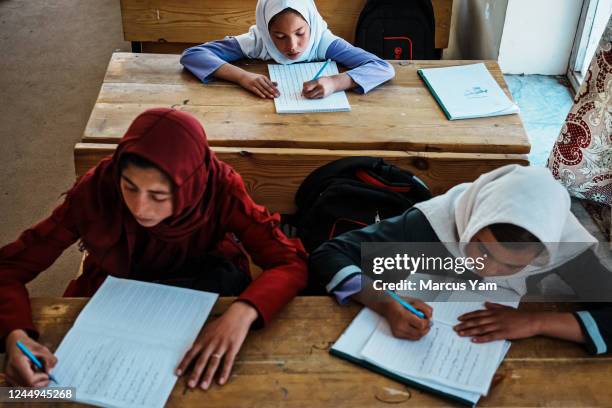 Somira Mousawi 16, left, Sharifa Bahmani right, and Zoha, 11 top, attend class at a school in Bamyan, Afghanistan, Monday, Sept. 5, 2022. A year...