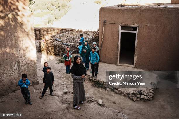 Zahra Wafa, center, stands with all her children along with neighborhood kids, outside their home in Nawa Foladi, a village with a single dirt track,...