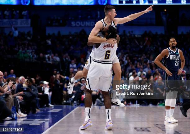 Vlatko Cancar of the Denver Nuggets celebrates with teammate DeAndre Jordan after making a long range three point basket as Spencer Dinwiddie of the...