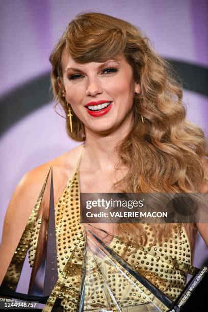 Singer Taylor Swift poses with her six trophies during the 50th Annual American Music Awards at the Microsoft Theater in Los Angeles, California, on...