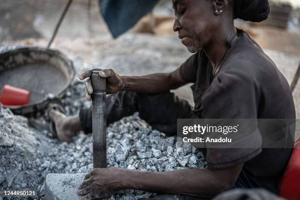 Briggite, a former hairdresser who lost everything in 2011 during a flood, breaks granite into smaller pieces in a granite mine in Ouagadougou,...