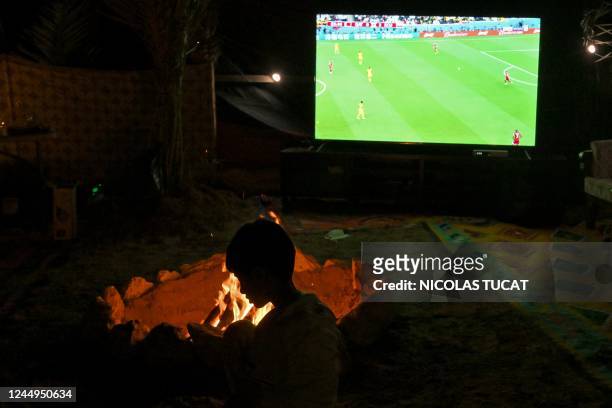 Boy watches on TV the Qatar 2022 World Cup football tournament opening Group A match between Qatar and Ecuador, at a desert camp north of Doha, on...