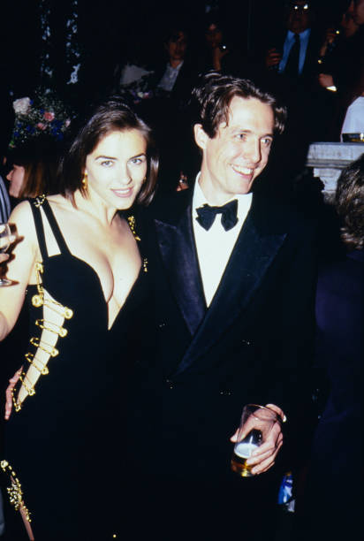 Elizabeth Hurley and Hugh Grant attend the UK premiere of 'Four Weddings and A Funeral'. Elizabeth Hurley, famously wearing a Versace dress held...