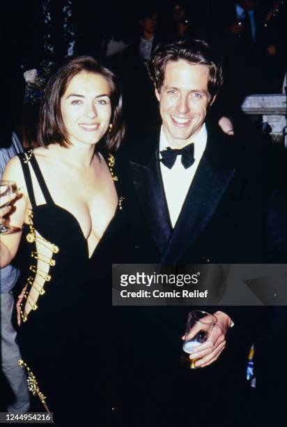 Elizabeth Hurley and Hugh Grant attend the UK premiere of 'Four Weddings and A Funeral'. Elizabeth Hurley, famously wearing a Versace dress held...