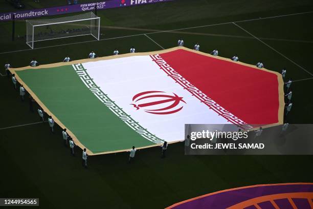 Giant national flag of Iran is displayed on the pitch at the Khalifa International Stadium before the start of the Qatar 2022 World Cup Group B...