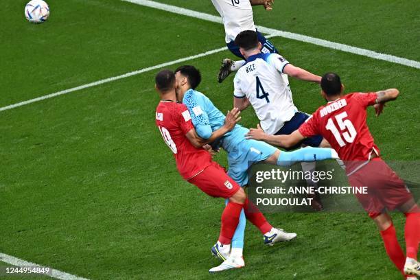 Iran's goalkeeper Alireza Beiranvand crashes with Iran's defender Majid Hosseini during the Qatar 2022 World Cup Group B football match between...