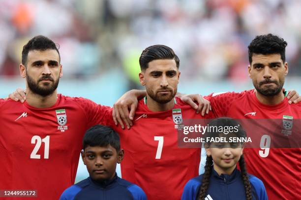 Iran's midfielder Ahmad Noorollahi, Iran's midfielder Alireza Jahanbakhsh and Iran's forward Mehdi Taremi listen to the national anthem ahead of the...