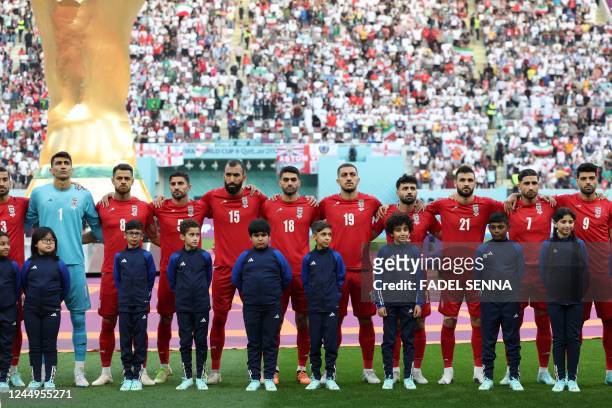 Iran players listen to the national anthem ahead of the Qatar 2022 World Cup Group B football match between England and Iran at the Khalifa...