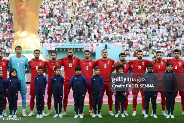 Iran players listen to the national anthem ahead of the Qatar 2022 World Cup Group B football match between England and Iran at the Khalifa...