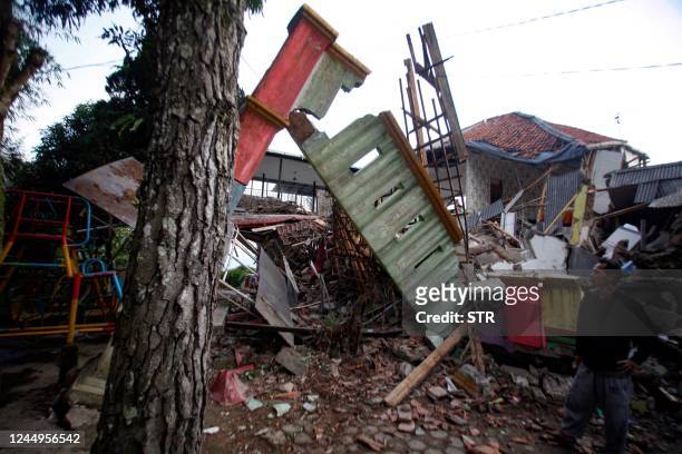 Man stands beside damaged houses following an earthquake in Cianjur on November 21, 2022. - At least 56 people were killed in an earthquake that...