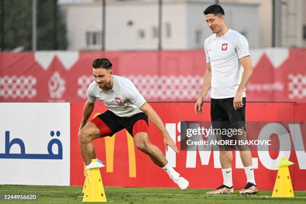 Poland's forward Robert Lewandowski and Poland's defender Matthew Cash take part in a training session at the Al Kharaititat SC Training Site in Doha...