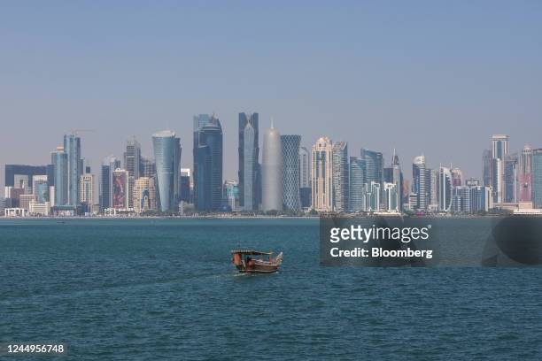Dhow boat sails in the water, backdropped by commercial and residential skyscrapers, including the Qatar Financial Centre in Doha, Qatar, on Monday,...