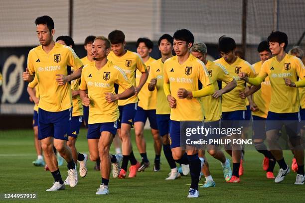 Japan's defender Maya Yoshida and Japan's defender Yuto Nagatomo take part in a training session with teammates at the Al Sadd SC training grounds in...