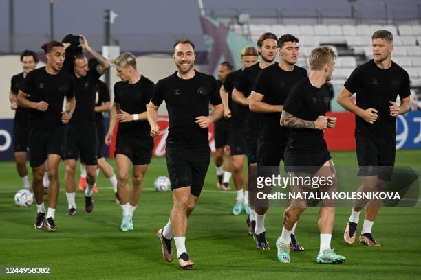 Denmark's midfielder Christian Eriksen and teammate take part in a training session at the al Sailiya SC Training Site in Doha on November 21 on the...