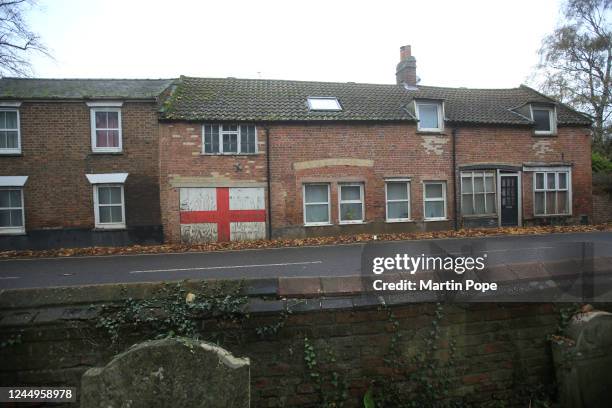 Large painted England flag panel is displayed in a row of cottages opposite the church on November 21, 2022 in Elm, England. On the second day of the...