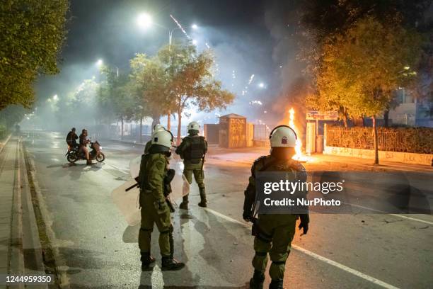 Riot police officers outside of the Polytechnic faculty while fireworks are fired against them and fire from molotovs are on the streets and bins...