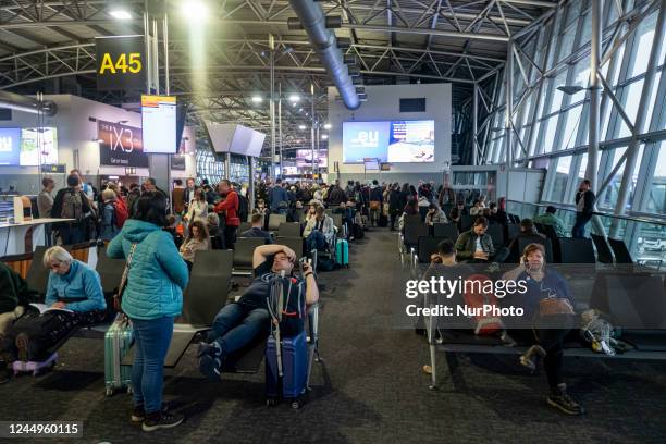 General view of the gates area in Brussels Airport with illuminated signs for the gates. Morning departing and arriving passengers are seen carrying...