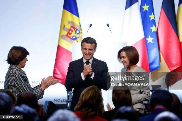 French President Emmanuel Macron reacts following his speech, flanked by French Foreign Minister Catherine Colonna and Moldovan President Maia Sandu...