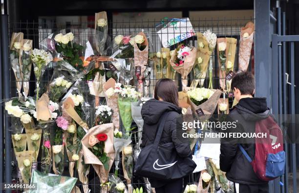 People look at flowers on the gates of Germillac College on November 21, 2022 in Tonneins, southwesternFrance, after a 14-year-old girl was kidnapped...
