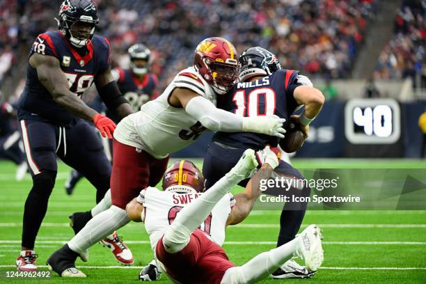 Houston Texans quarterback Davis Mills is sacked by Washington Commanders defensive end Montez Sweat and Washington Commanders defensive tackle...