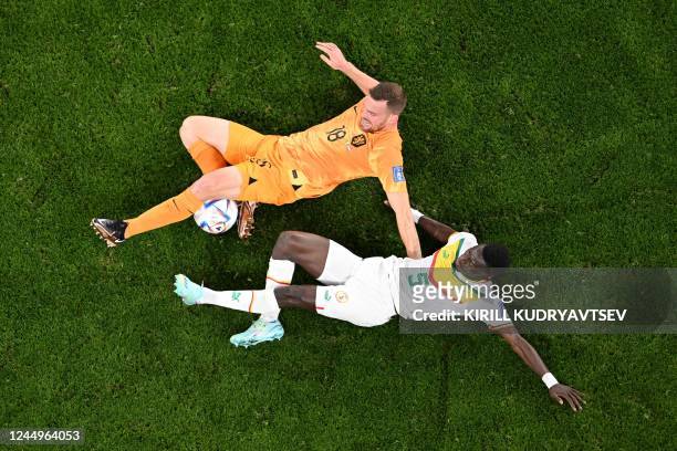 Netherlands' forward Vincent Janssen fights for the ball with Senegal's midfielder Idrissa Gana Gueye during the Qatar 2022 World Cup Group A...
