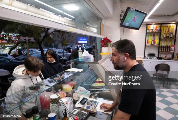 An Iranian trader receives order from his costumer while the soccer match between Iran and England of Group B of the Qatar 2022 World Cup in Khalifa...