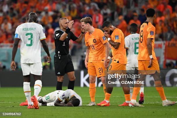 Senegal's midfielder Cheikhou Kouyate lies on the pitch after he sustained an injury during the Qatar 2022 World Cup Group A football match between...