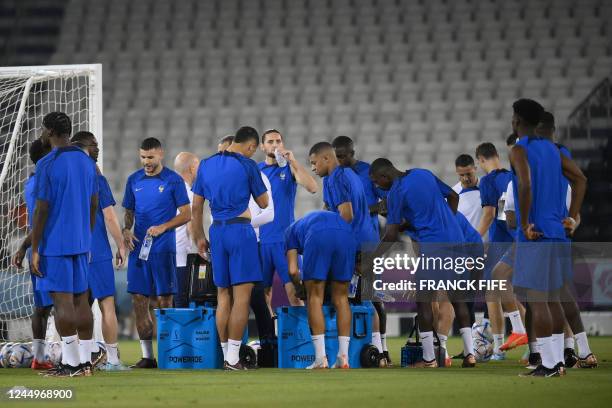 France's players including forward Kylian Mbappe stop for a drinks break during a training session in Doha, on November 21 on the eve of the Qatar...