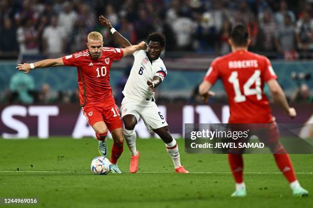 Wales' midfielder Aaron Ramsey and USA's midfielder Yunus Musah fight for the ball during the Qatar 2022 World Cup Group B football match between USA...