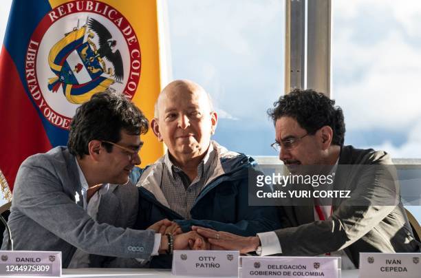 The Colombian government delegation members, peace commissioner Danilo Rueda Otty Patino and Ivan Cepeda join hands during a press conference to...
