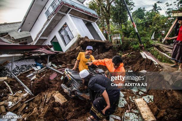 Villagers salvage items from damaged houses following a 5.6-magnitude earthquake that killed at least 162 people, with hundreds injured and others...