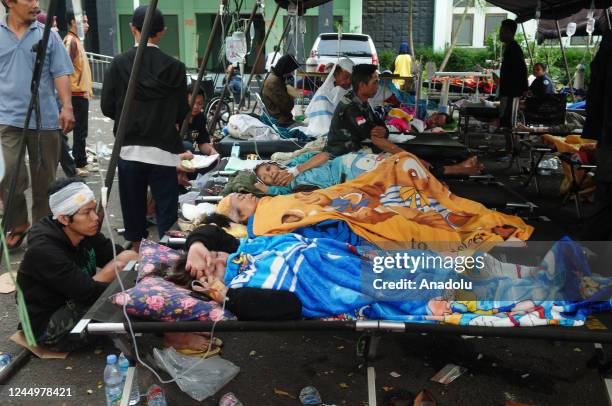 Earthquake victims receive treatment in an emergency tent which are established after hospital becomes full capacity at the Sayang Regional General...