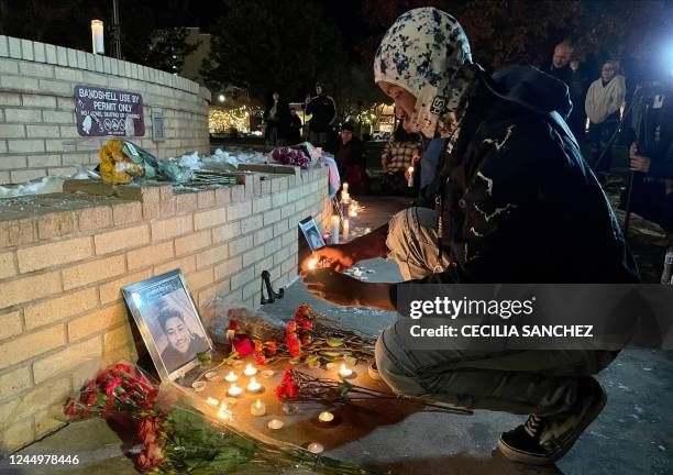 Friend of victim Raymond Green Vance lights candles in front of his portrait during a vigil for the victims of a mass shooting at Club Q, an LGBTQ...